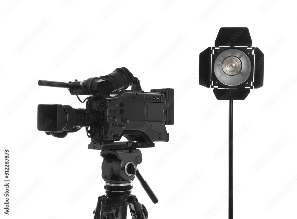 Professional video camera and lighting equipment isolated on white