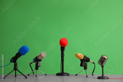 Microphones on table against green background. Journalist's work