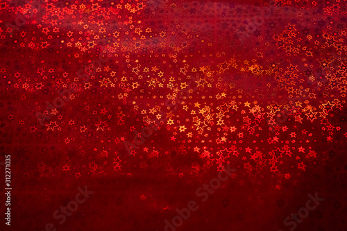Red abstract stars of all sizes sparkling background. Wraping paper with glittering effect.