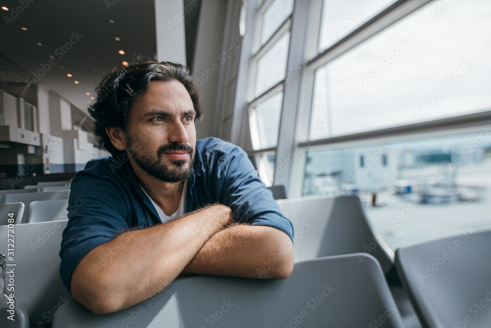 A man sits in a waiting room at the gate at the airport. A man sits in a waiting room at the gate at the airport.