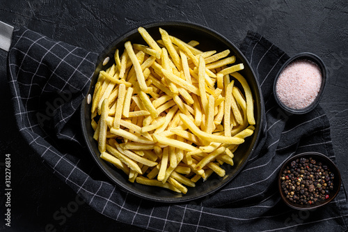 Vászonkép Frozen French fries in a frying pan. Black background. Top view