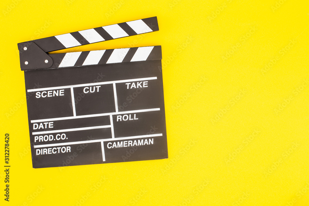 top view of black clapperboard isolated on yellow