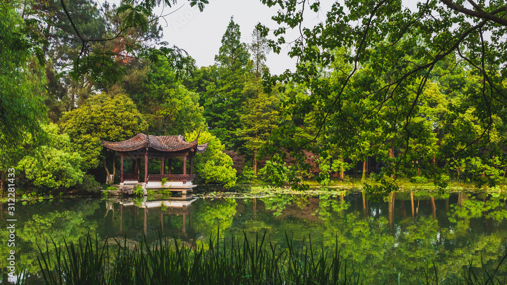 Traditional Chinese architecture by water in park by West Lake, in Hangzhou, China