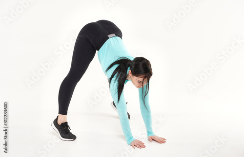 Young athletic woman making yoga and gymnastics stretching exercises isolated on white 
