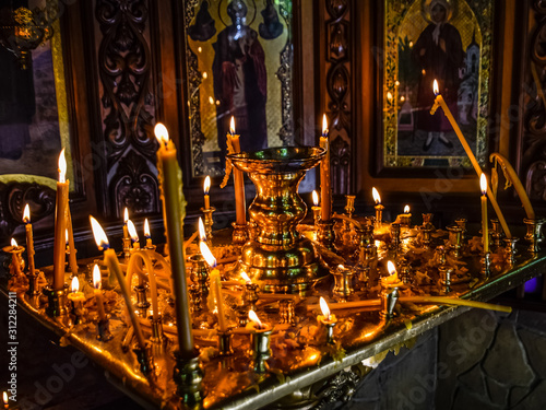 Burning candles on a stand near the icons in the chapel.