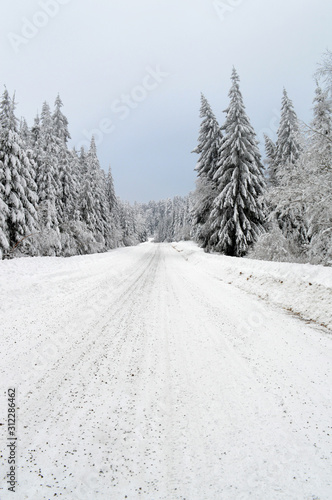 Beautiful winter landscape with a dangerous and slippery snow-covered mountain road