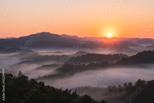 Sunrise on the mountain in winter and fog floats over the mountains.