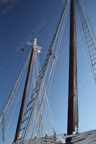 Masts and rigging of sailboat against blue sky background