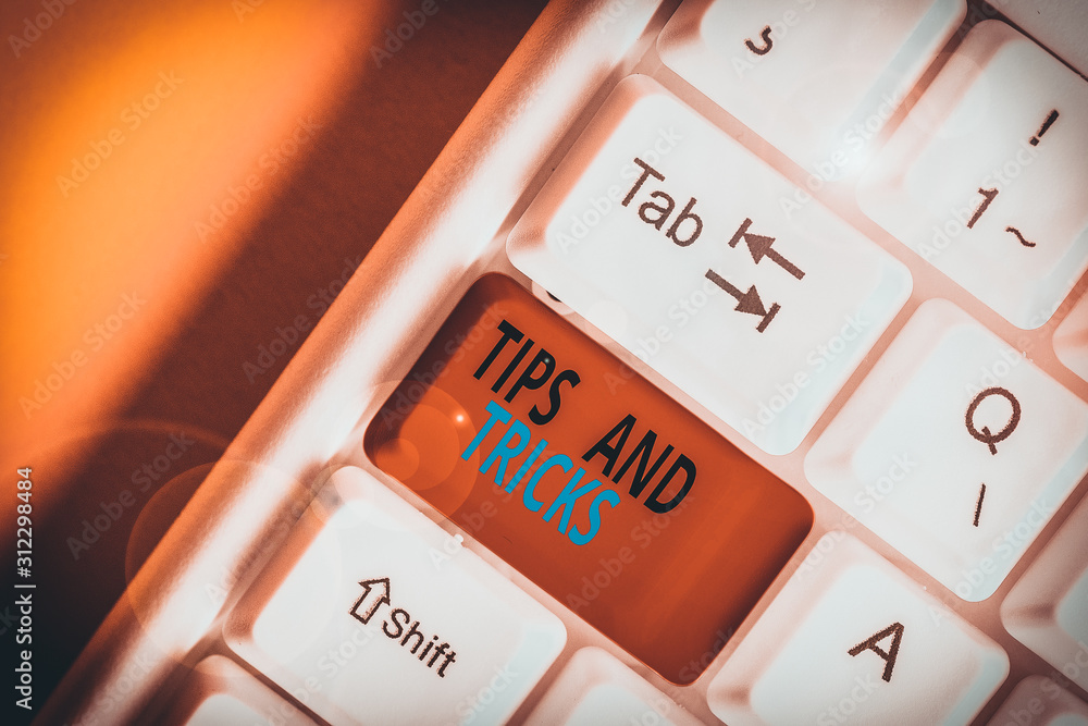 Obraz premium Conceptual hand writing showing Tips And Tricks. Concept meaning means piece advice maybe suggestion how improve White pc keyboard with note paper above the white background