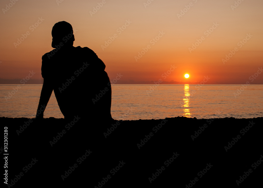 silhouette of a guy on a sunset on the beach