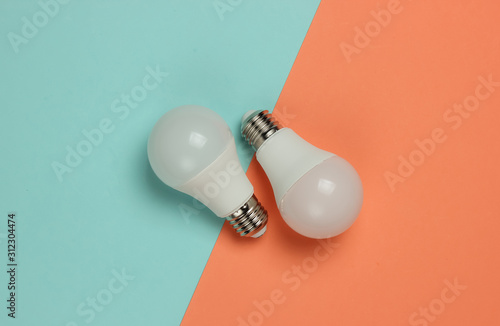 Three LED light bulbs on pink blue background. Top view