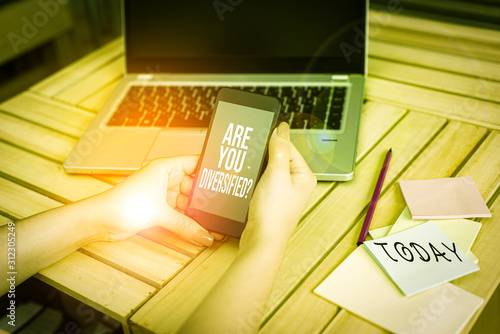 Text sign showing Are You Diversified Question. Business photo showcasing someone who is Different Mixed Multi Faceted woman laptop computer smartphone office supplies technological devices photo