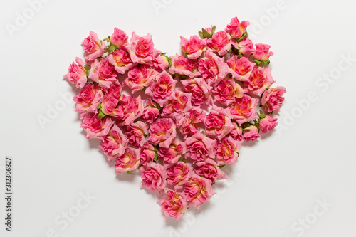 Romantic Valentines day greeting card with heart made of pink roses on white backgound.