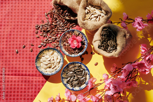 Fototapeta Naklejka Na Ścianę i Meble -  Small sacks and bowls with seeds for spring festival on decorated table, view from above