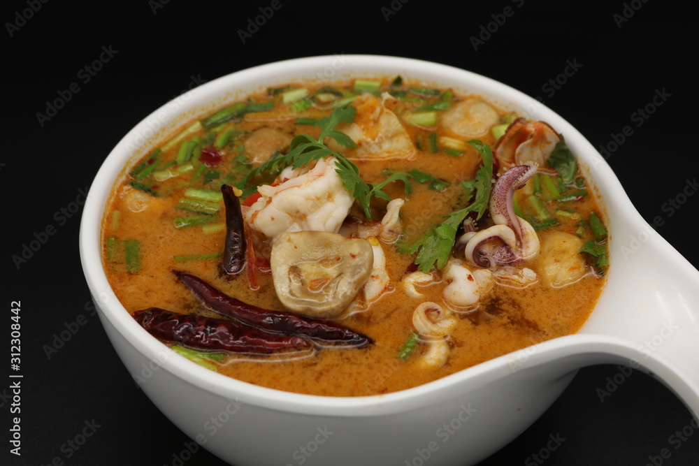 Tomyum (Thai spicy soup) with prawn and squid in herbs, mushroom and chili soup Tomyum (Thai spicy soup) with prawn and squid in herbs, mushroom and chili soup