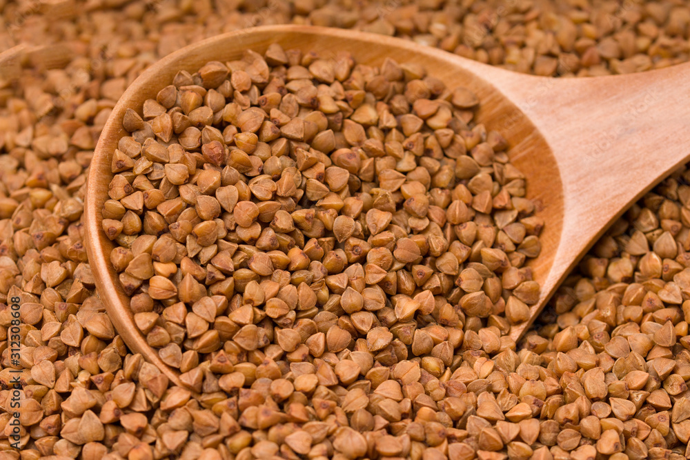 Buckwheat with a wooden spoon, background image. Buckwheat with a wooden spoon, background image.