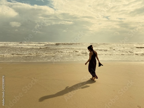 woman walking on the beach at sunset