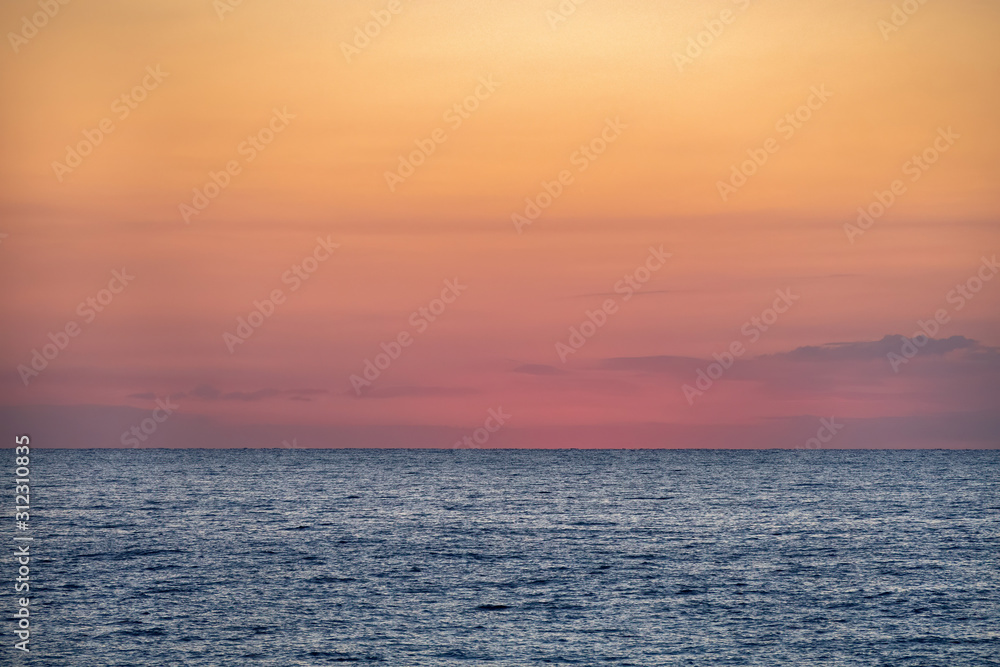 Blue sea with orange yellow sky at the dawn. Barcelona, Spain. Copy space.