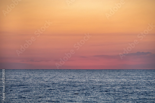 Blue sea with orange yellow sky at the dawn. Barcelona, Spain. Copy space.