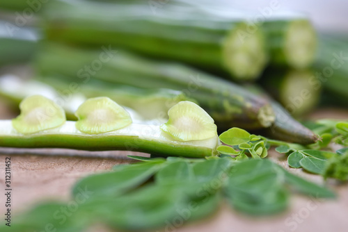 Moringa oleifera, Moringa leaves and Moringa seed Healthy green vegan super food- Fresh harvested organic Moringa [ drum stick } vegetable  on wood background. Selected focus photo