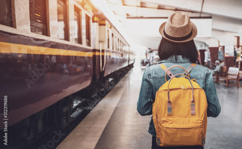 Fotografie, Obraz Young asian woman traveler with backpack in the railway, Backpack and hat at the train station with a traveler, Travel concept