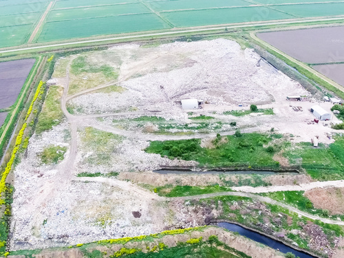 garbage dump with heaps of garbage and treatment facilities. Landfill of garbage outside the village photo