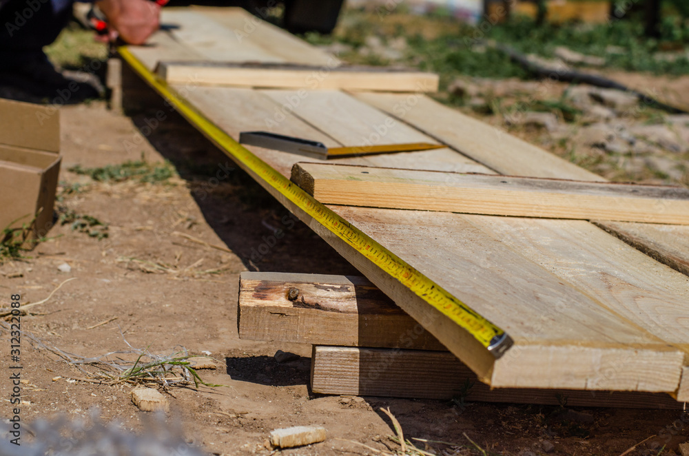 yellow measuring tape measures the formwork boards