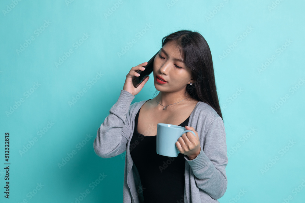 Young Asian woman with mobile phone and coffee cup. Young Asian woman with mobile phone and coffee cup.