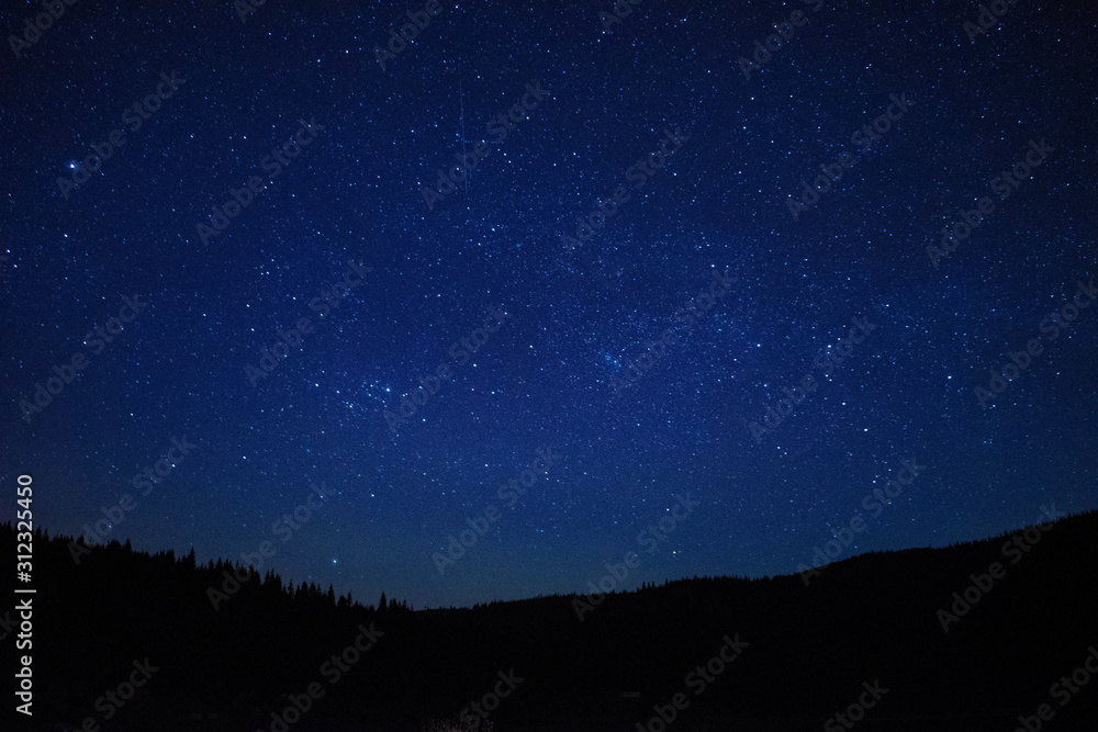 Calm night with shiny stars in the mountains.