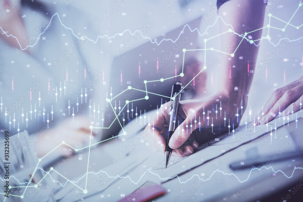 A woman hands writing information about stock market in notepad. Forex chart holograms in front. Concept of research. Double exposure A woman hands writing information about stock market in notepad. Forex chart holograms in front. Concept of research. Double exposure