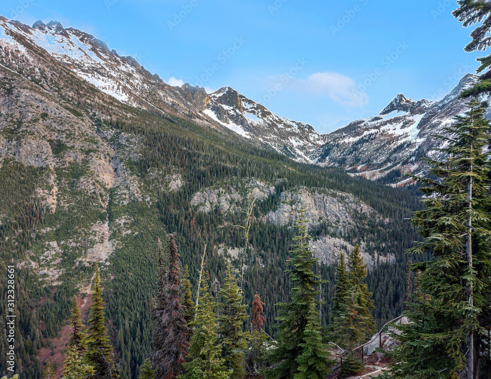 Fototapeta premium Magnificent views of snow capped mountains and alpine trees in the pristine wilderness in the fall from the Washington Pass Overlook trail in North Cascade National Park outside Winthrop Washington