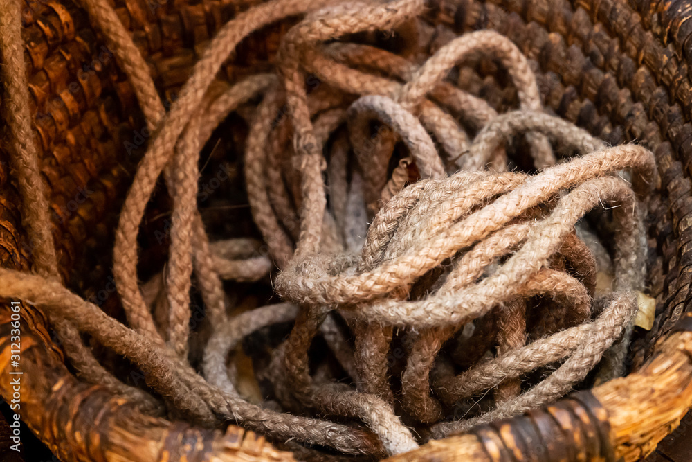 tough solid brown rope natural old pile close-up in a wooden basket