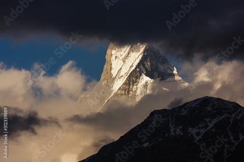 Clouds cover the peak of Machapuchare aka Fishtail mountain on the Annapurna Base Camp trail in the Nepal Himalaya. photo