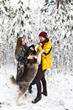 Couple in love and dog  breed Siberian Husky in a winter snowy forest on nature