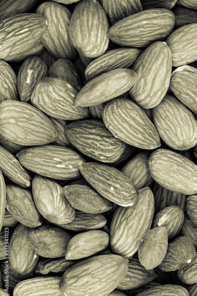 Fototapeta premium vertical pattern tinted gray almonds many nuts base background