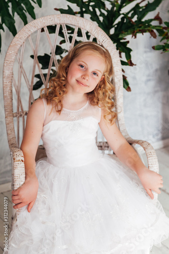 Portrait of a beautiful blonde girl in a white dress