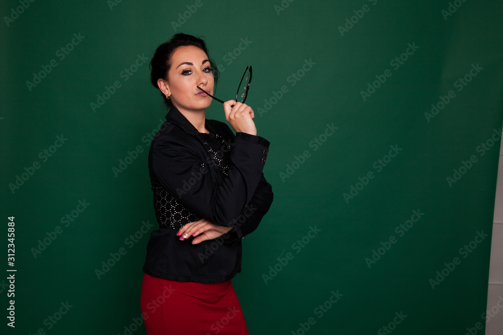 beautiful female teacher in business suit against a green background beautiful female teacher in business suit against a green background