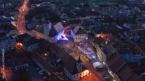 Christmas fair with decoration and bright lights on main square of small town in Europe  aerial view of old medieval town center