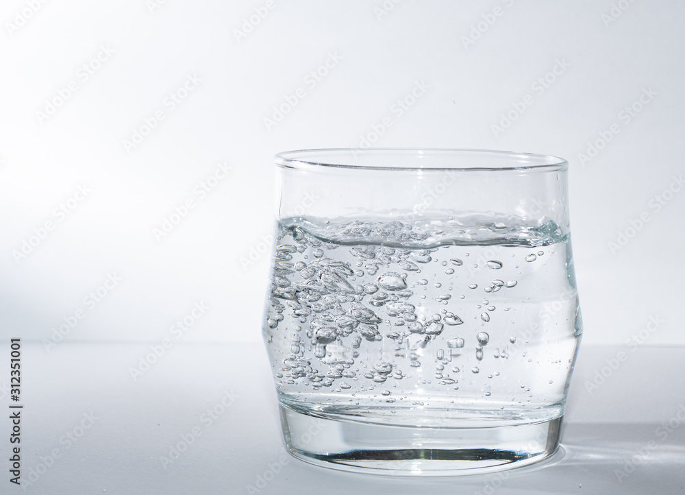 Kleiner Wasserglas gefüllt mit Wasser mit Sprudel Kleiner Wasserglas gefüllt mit Wasser mit Sprudel