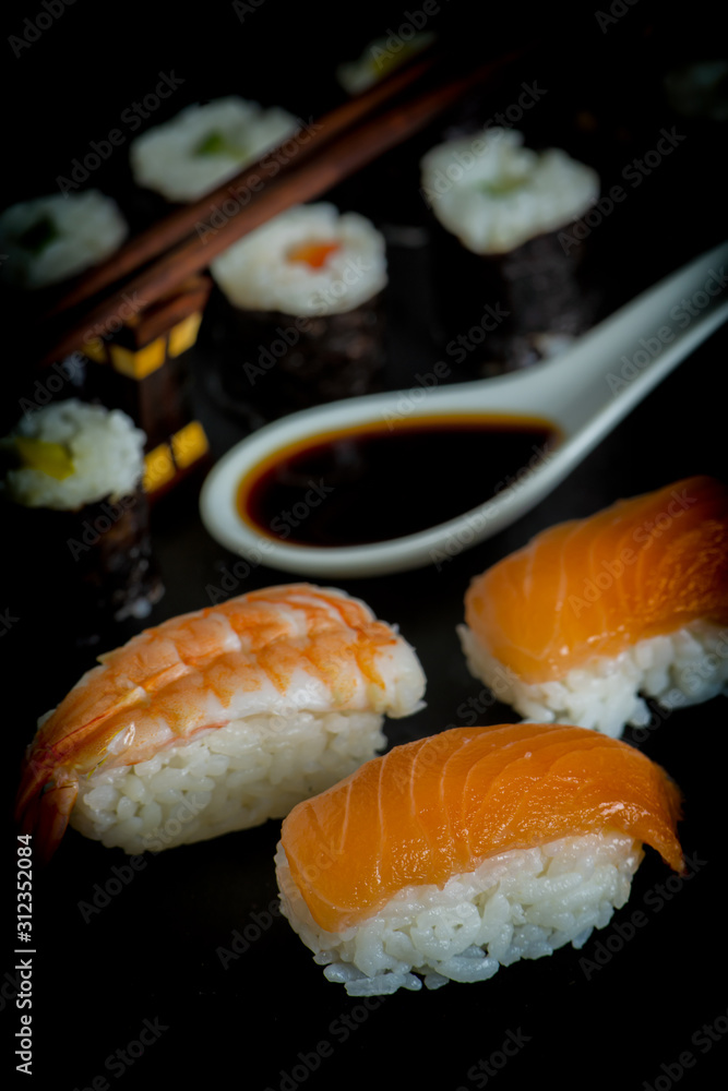 Salmon and prawns sushi with soy sauce on a dark background. Salmon and prawns sushi with soy sauce on a dark background.