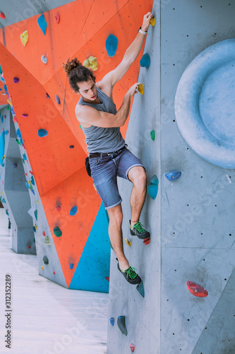 Man on artificial exercise climbing wall