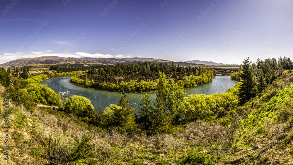 Panoramic view of river canyon with dark water and spring