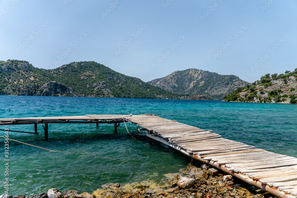Wood dock in ocean with mountains