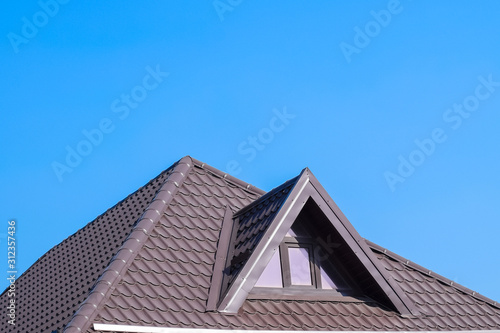 House with plastic windows and a brown roof of corrugated sheet