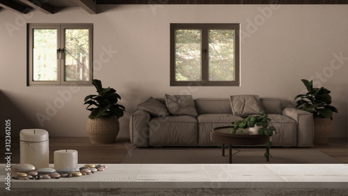 Wooden vintage table top or shelf with candles and pebbles, zen mood, over country house living room, lounge with wooden roof, mezzanine loft, sofa with pillows, carpet and plants