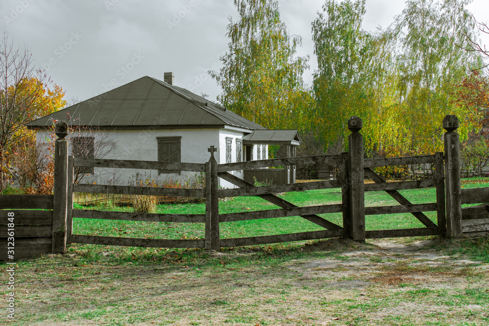 Rural house behind a wooden fence