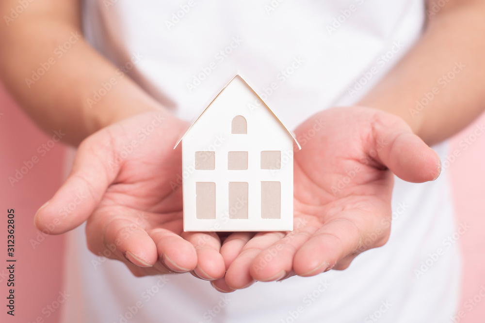 Small white house on human hand Small white house on human hand