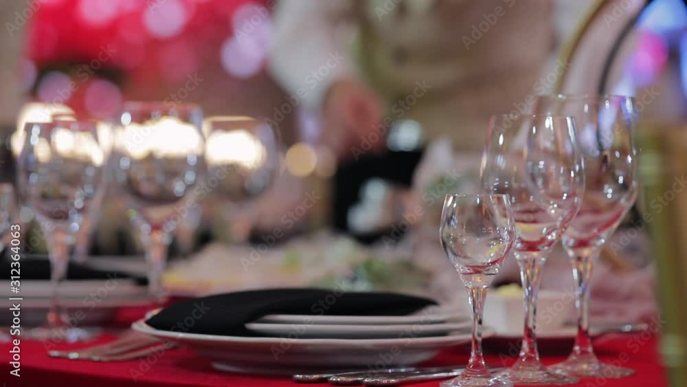 Cutlery on table with a red tablecloth in rays of light from the music scene. The festive dinner in luxury restaurant Cutlery on table with a red tablecloth in rays of light from the music scene. The festive dinner in luxury restaurant