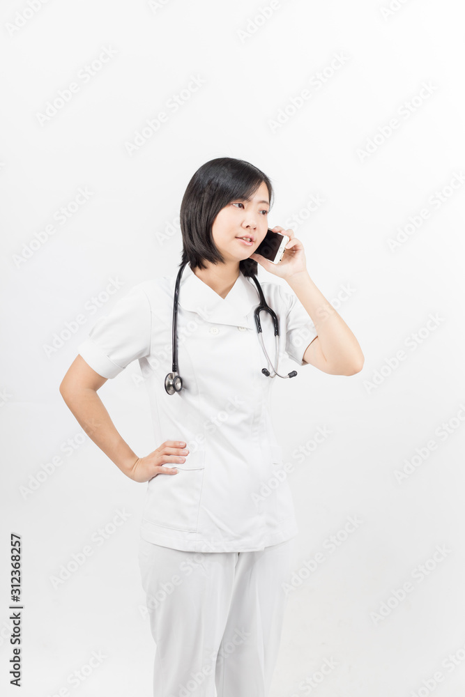 Young asian nurse with a stethoscope talking on the phone, isolated over white background. Young asian nurse with a stethoscope talking on the phone, isolated over white background.