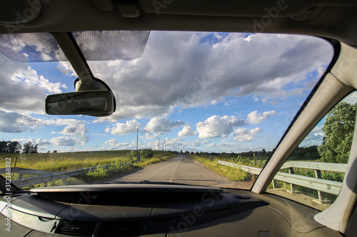 View of forest road through car glass.